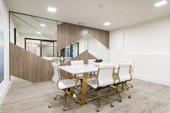 a meeting room with a marble table and white chairs