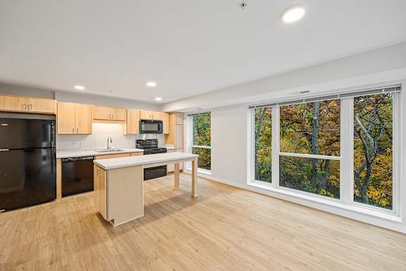 a kitchen with a large window and a island with a counter top