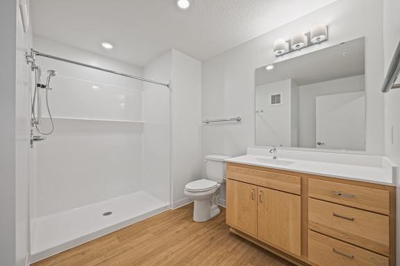 a bathroom with a toilet sink and shower and a mirror