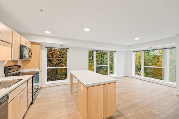 a kitchen with a large window and a table in the middle