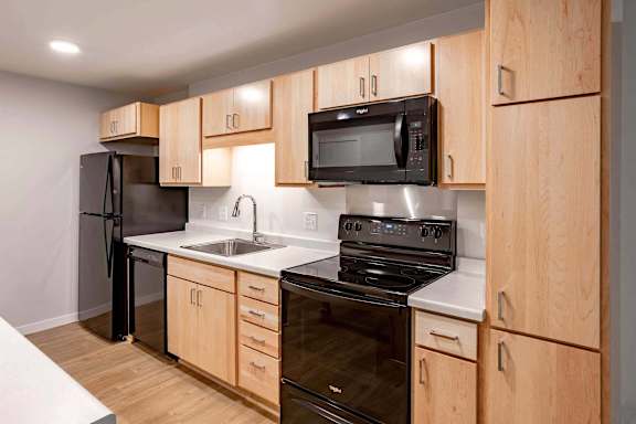 a kitchen with black appliances and wooden cabinets