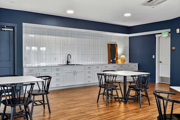 A kitchen with a table and chairs in front of a blue wall.