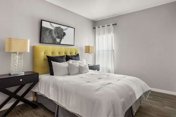 A bedroom with a yellow headboard and a white bedspread.