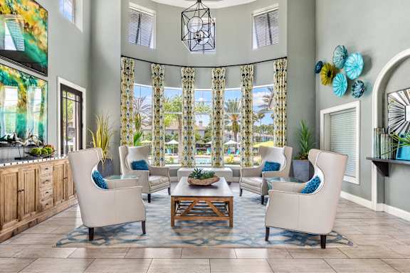 A living room with a large window and a view of a pool.