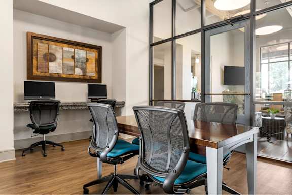 A conference room with a wooden table and chairs.