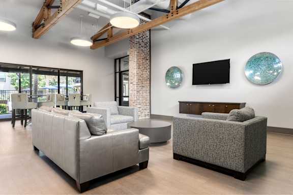 A living room with a grey couch and a black television.