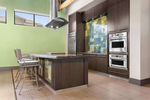 A modern kitchen with a green wall and a wooden island.