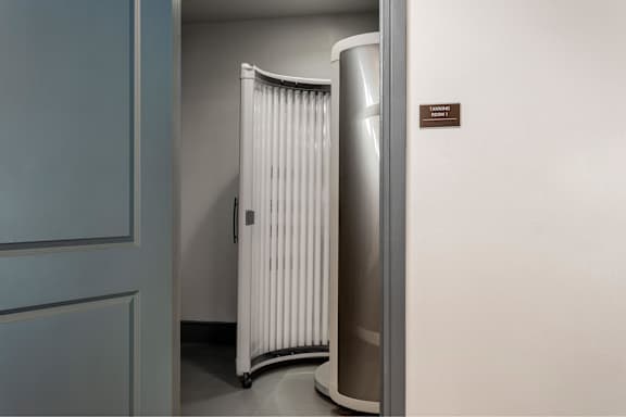 A white radiator is in a corner of a room.