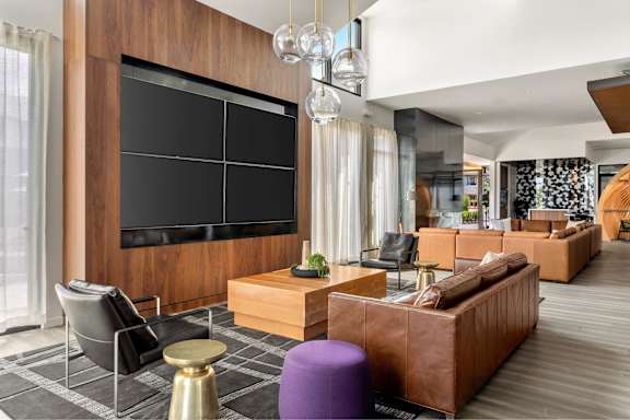A modern living room with a large flat screen TV mounted on the wall.