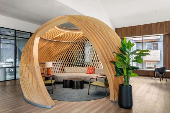 A wooden structure in a room with a couch and a potted plant.