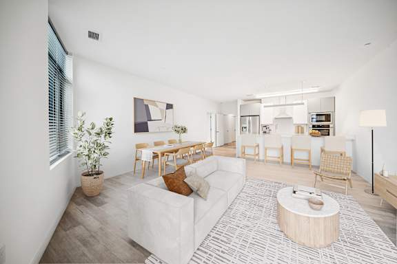 A living room with a white couch and a wooden coffee table.