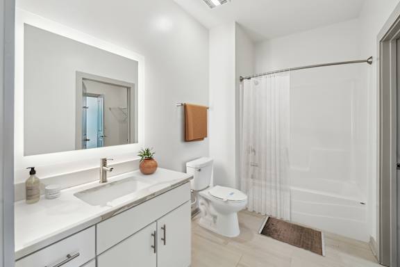 A white bathroom with a toilet, sink, and shower.