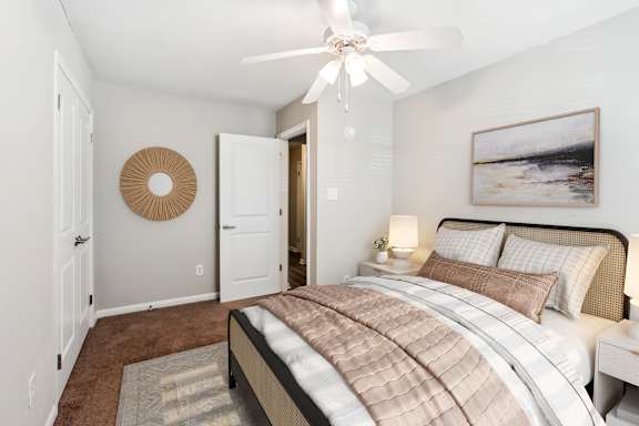 A bedroom with a large bed and a painting on the wall.