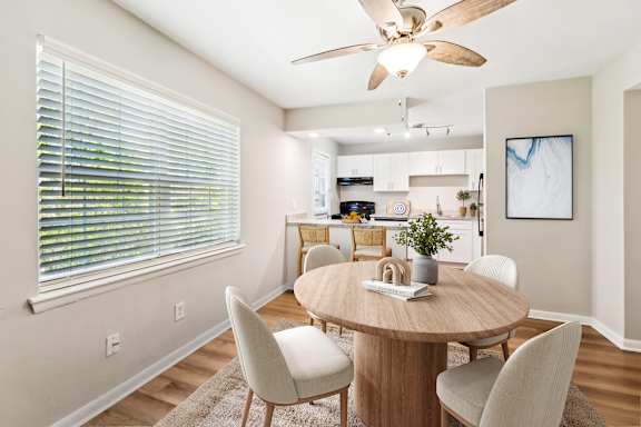 A dining room with a round table and chairs.
