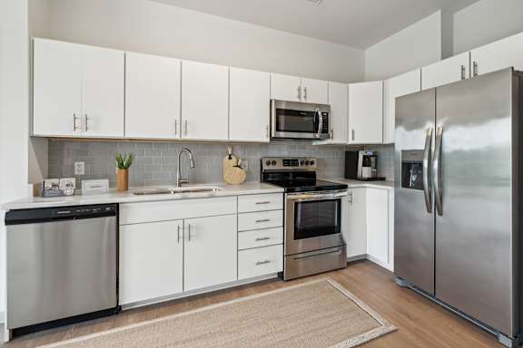 A modern kitchen with stainless steel appliances and white cabinets.