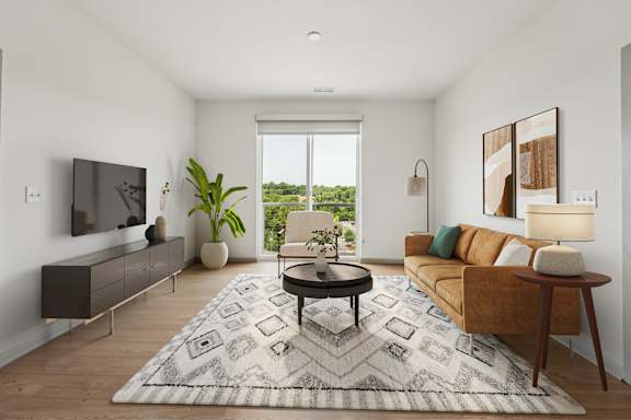A living room with a brown couch, a black coffee table, and a large window.