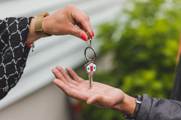 a person handing a house key to another person  at Coventry Heights Senior, Westminster, 92683