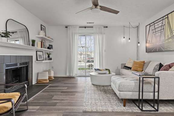 A living room with a fireplace, a couch, and a rug.