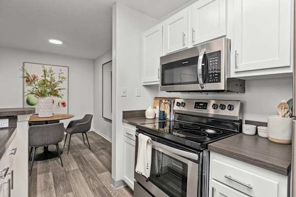 A modern kitchen with a stove top oven and microwave above it.