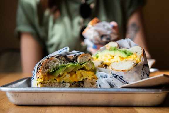 A person is holding a burrito with a bite taken out of it.