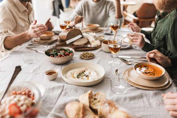 A group of people are sitting around a table enjoying a meal together.
