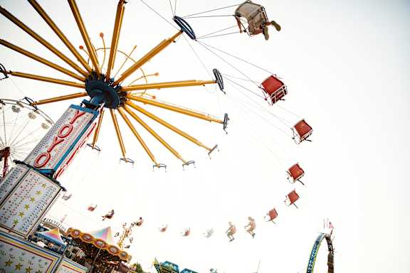 A large wheel with multiple seats attached to it is spinning.