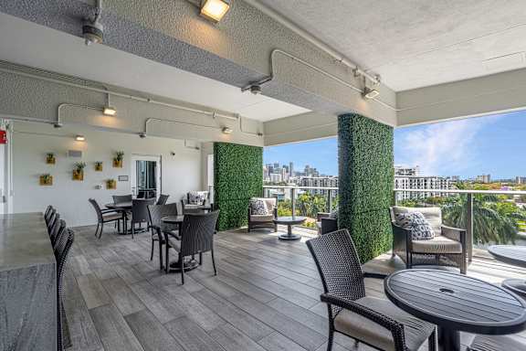 a balcony with tables and chairs and a view of the city