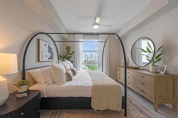 a bedroom with a bed and a large window