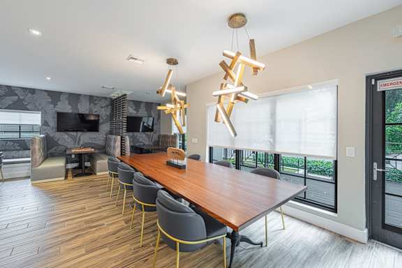 a dining room with a wooden table and chairs and a large window