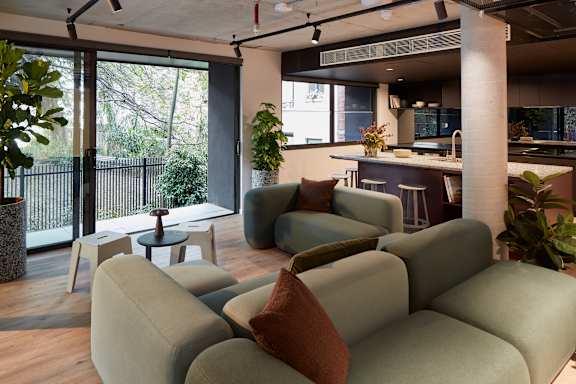 a living room with a couch and a kitchen in the background