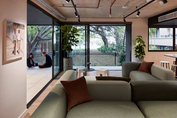 a living room with couches and a table and some windows