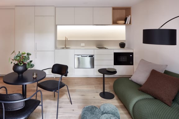 a kitchen and living room with a green couch and a table