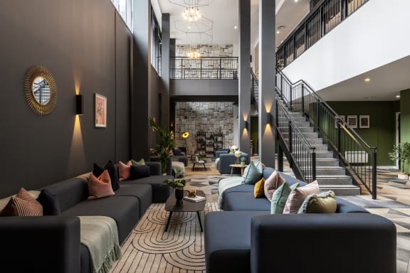 the lobby of a hotel with couches and a staircase