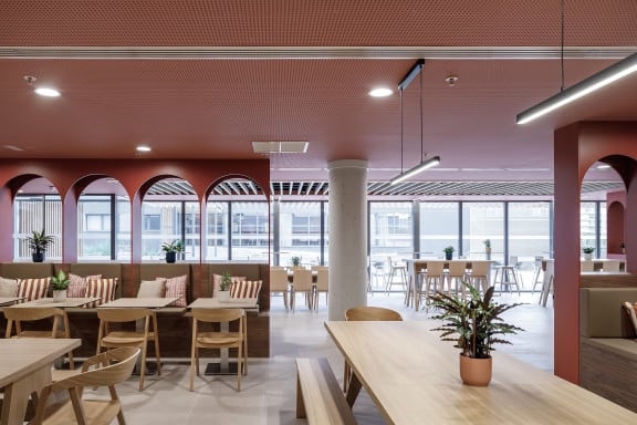a large dining room with tables and chairs and large windows