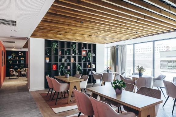 a dining room with tables and chairs and a bookshelf