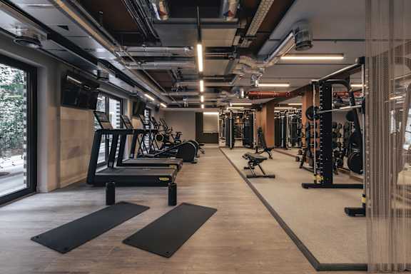 A gym with a variety of equipment including treadmills, weights, and exercise machines.