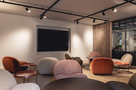 A room with a television and several chairs.