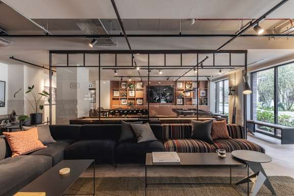 A modern living room with a black sofa and a coffee table.