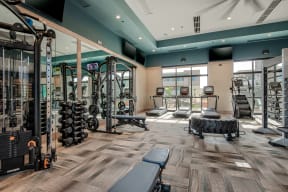 a spacious fitness center with cardio machines and weights