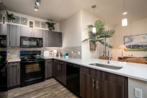a kitchen with dark wood cabinets and white countertops