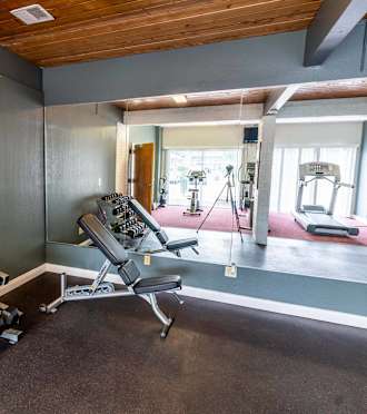 a gym with treadmills and other exercise equipment in a home