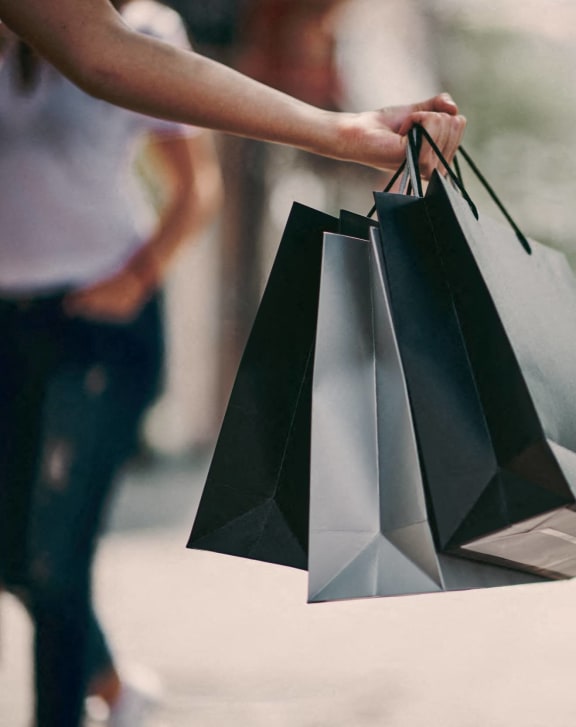 a woman holding shopping bags in a store