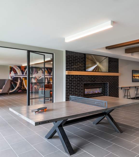 a dining room with a ping pong table and a large window at The Rail, St. Louis, 63110
