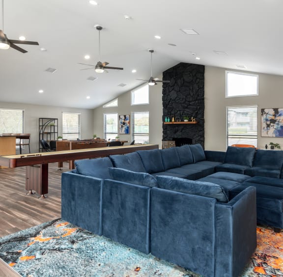 a living room with a blue couch and a pool table