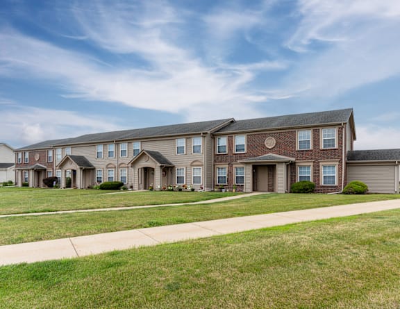 a brick apartment building with a sidewalk in front of it