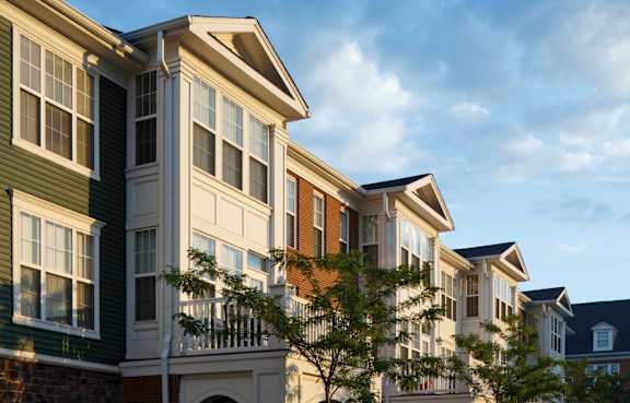 A row of houses with white windows and balconies.