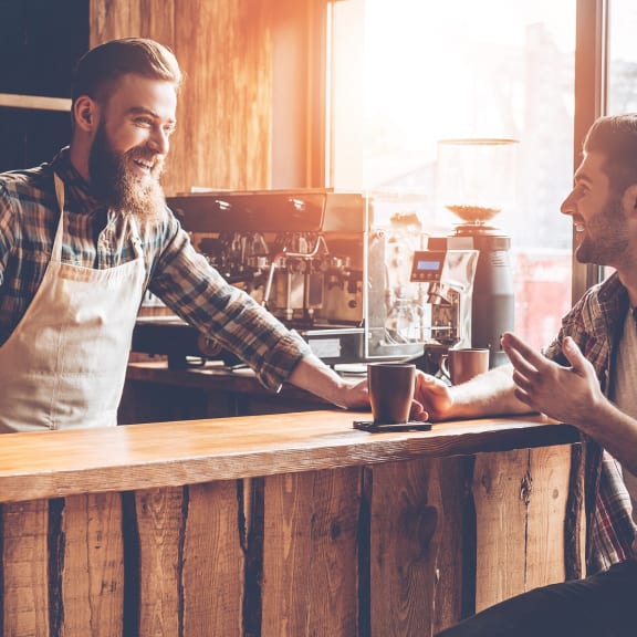 two men sitting at a bar talking to each other