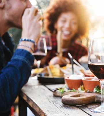 people sitting at a table with food and wine