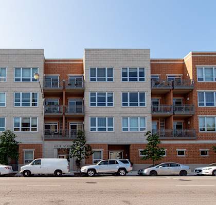 a large apartment building with cars parked in front of it