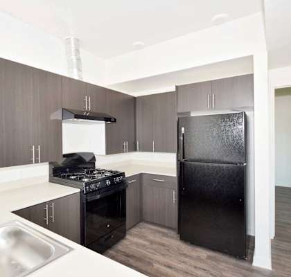 a kitchen with black appliances and white countertops